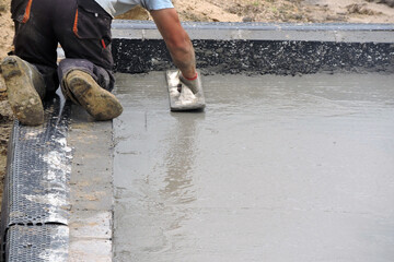 A building worker hand floating the wet concrete