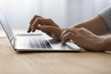 Using laptop. Close up of young man employee office worker student freelancer hands typing on...