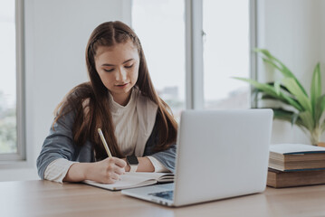 Caucasian girl learning online class from school. girl using laptop learning online education from home.