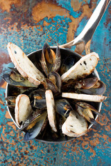 Mussels with lemon in a pan. Photo of food on a dark background