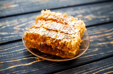 honey in honeycombs on a brown wooden background
