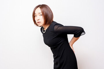 腰に手を当てている喪服を着ている女性