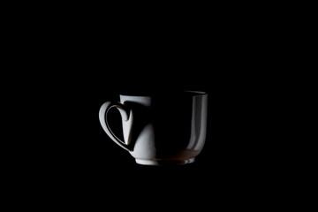 Cup of coffee and heart-shaped shadow with smoke on black background, This photo is available...