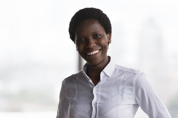 Headshot of happy African businesswoman, professional corporate trainer or business coach portrait. Confident attractive promoted company employee, staff member posing in office smile look at camera