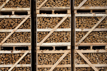 Chopped dry firewood stacked in large wooden containers. Dry chopped firewood. Background from dry...