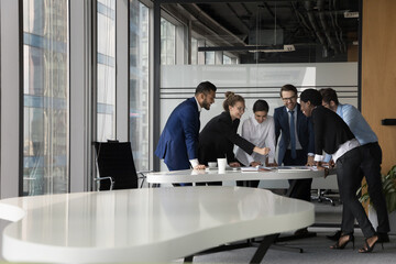 In modern office boardroom gather six multi racial positive successful business people lean at...
