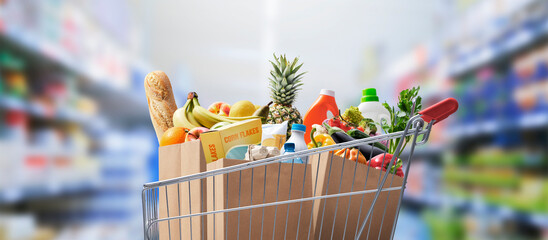 Shopping cart full of groceries - obrazy, fototapety, plakaty