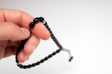 Hand holding a black muslim rosary beads