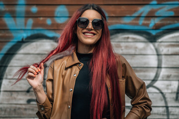 red-haired girl in sunglasses smiling on the street