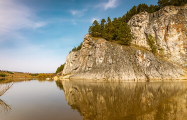 Spring landscape with rocks, forest on the river bank against the blue sky. Russia. Ural. Aramashevo