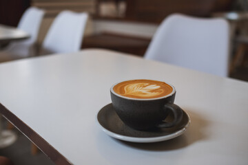 A cup of hot latte coffee on the table in cafe