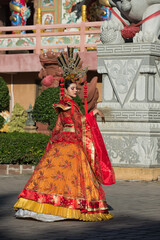 Fototapeta na wymiar statue of a woman in a dress. portrait of a woman. person in traditional costume. woman in traditional costume. Beautiful young woman in a bright red dress and a crown of Chinese Queen posing 