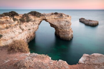 Fototapeta na wymiar Natural arch above ocean, arco de Albandeira, Algarve, Lagoa portugal. Stone arch at beach. Summer season.