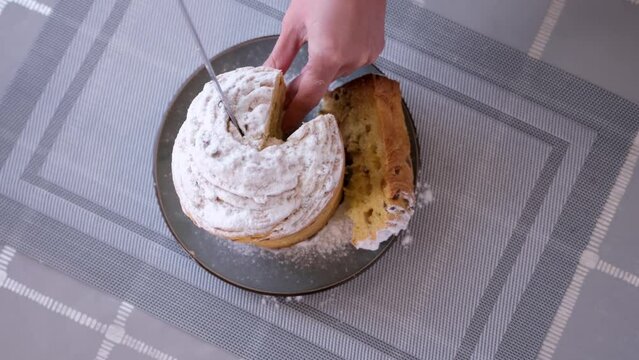 Woman taking piece of traditional Easter cruffin cake - Happy Easter concept