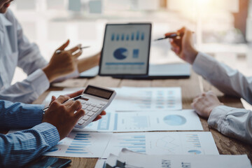 Business people discuss investment project working and planning strategy on digital tablet. Business people talking together with tablet at office.