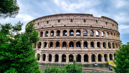 Fototapeta na wymiar Panoramic view on exterior facade of famous Colosseum (Coloseo) of city of Rome, Lazio, Italy, Europe. UNESCO World Heritage Site. Flavian Amphitheater of ancient Roman Empire. Concept tourism