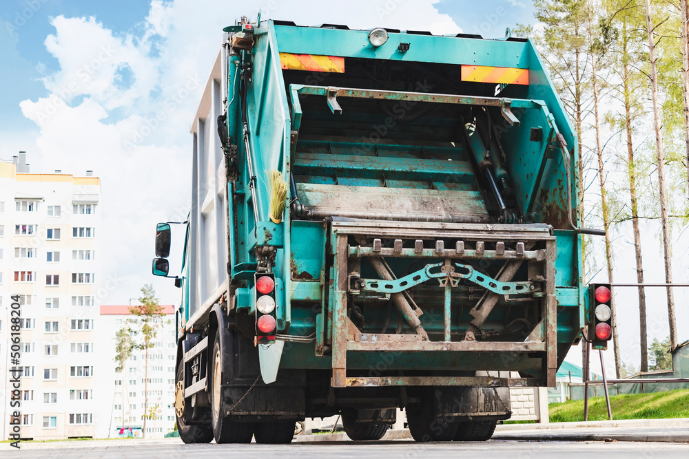 Aufkleber A garbage truck picks up garbage in a residential area. Loading mussar in containers into the car. Separate collection and disposal of garbage. Garbage collection vehicle.