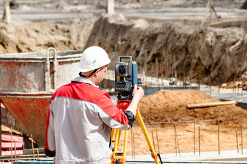 Construction of a residential area. Geodetic stakeout. Surveyor at a large construction site. A man...