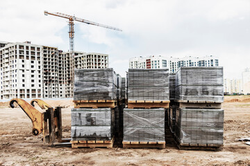 Storage of concrete road curbs on pallets at the construction site. Curb stones prepared for...