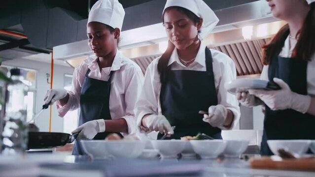 Group of schoolgirls having fun learning to cook. Female students in a cooking class.