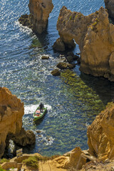 Panoramic view with Cliff, rocks and tourist boat on sea at Ponta da Piedade near Lagos, Algarve, Portugal