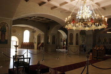 A large cathedral with black domes in the monastery. Beautiful church in a green park