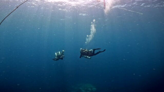 Under Water Film of two divers with extrs o2 takns in mid water at depth 4  meters beneath ocean surface - Thailand