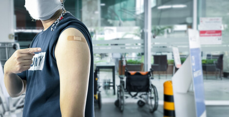 A third dose of COVID-19 vaccination is given to an Asian male.