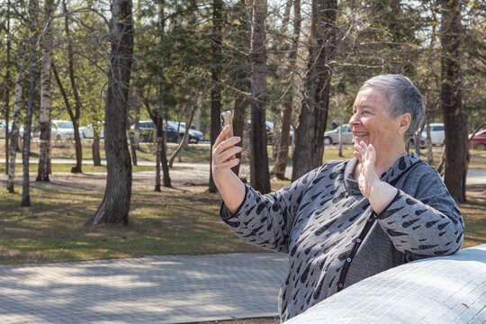 Attractive, smiling senior woman communicating with someone over mobile phone, selective focus.