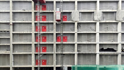Construction of a high concrete building with separate blocks, work in progress on a construction site, concrete construction with geometric shapes