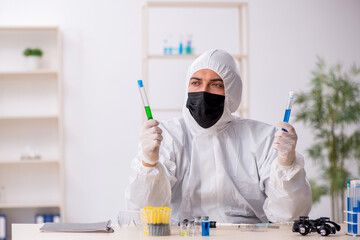 Young male chemist working at the lab during pandemic