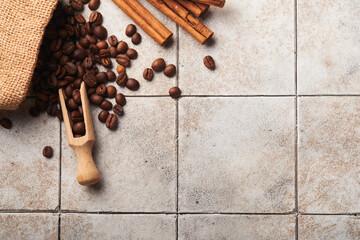 Coffee background. Measuring spoons with ground coffee, beans, cup and sweet chocolate truffles on old tile cracked table background. Food background. Top view with space for your text