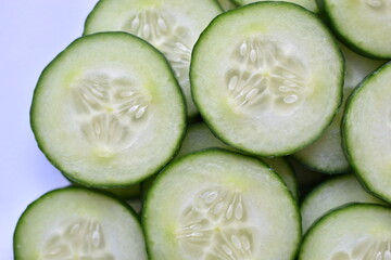 Sliced slices of green cucumber macro photo as background