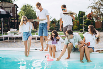 Friends having party near swimming pool,enjoying together.