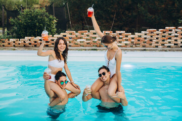 Friends have a party by the pool, enjoying together.