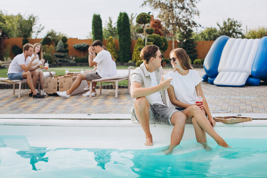 Friends having party near swimming pool,enjoying together.