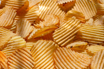 background corrugated golden chips with texture. selective focus, daylight