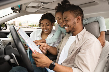Happy African Family Holding Map Sitting In Car Choosing Destination