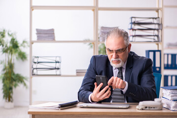 Old male employee working at workplace
