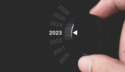 Hand rotate black knob to select 2023 year for preparation Merry Christmas and Happy new year...