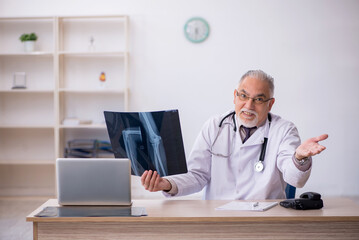 Old male doctor radiologist working at the hospital