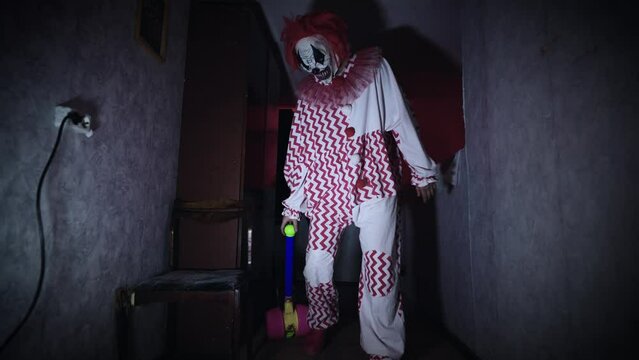Creepy and evil clown, in a gloomy and abandoned room.