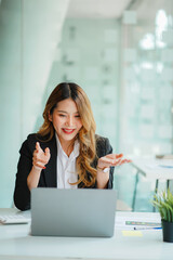 Asian business woman Working on laptop on desk . Independent woman reading financial graph chart. Marketing analysis planning hand of a girl working in the office