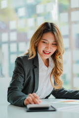 Fototapeta premium Asian business woman Working on laptop on desk . Independent woman reading financial graph chart. Marketing analysis planning hand of a girl working in the office