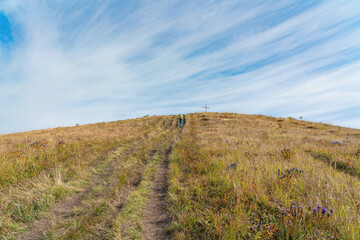 Fototapeta premium The hiker goes the trail to the top of the mountain (concept: the path to success)