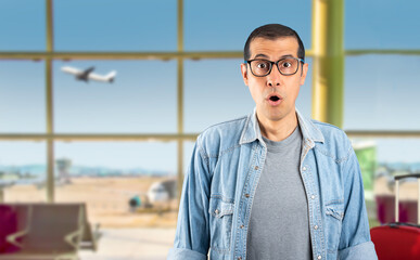 Adult hispanic man wearing glasses at airport afraid and shocked with surprise expression, fear and...