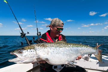 Big salmon fish holding by happy angler