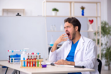 Fototapeta premium Young male chemist working at the lab