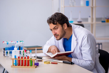 Young male chemist working at the lab