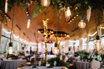 Vintage style light bulbs hanging from the ceiling. Wedding and holidays concept
